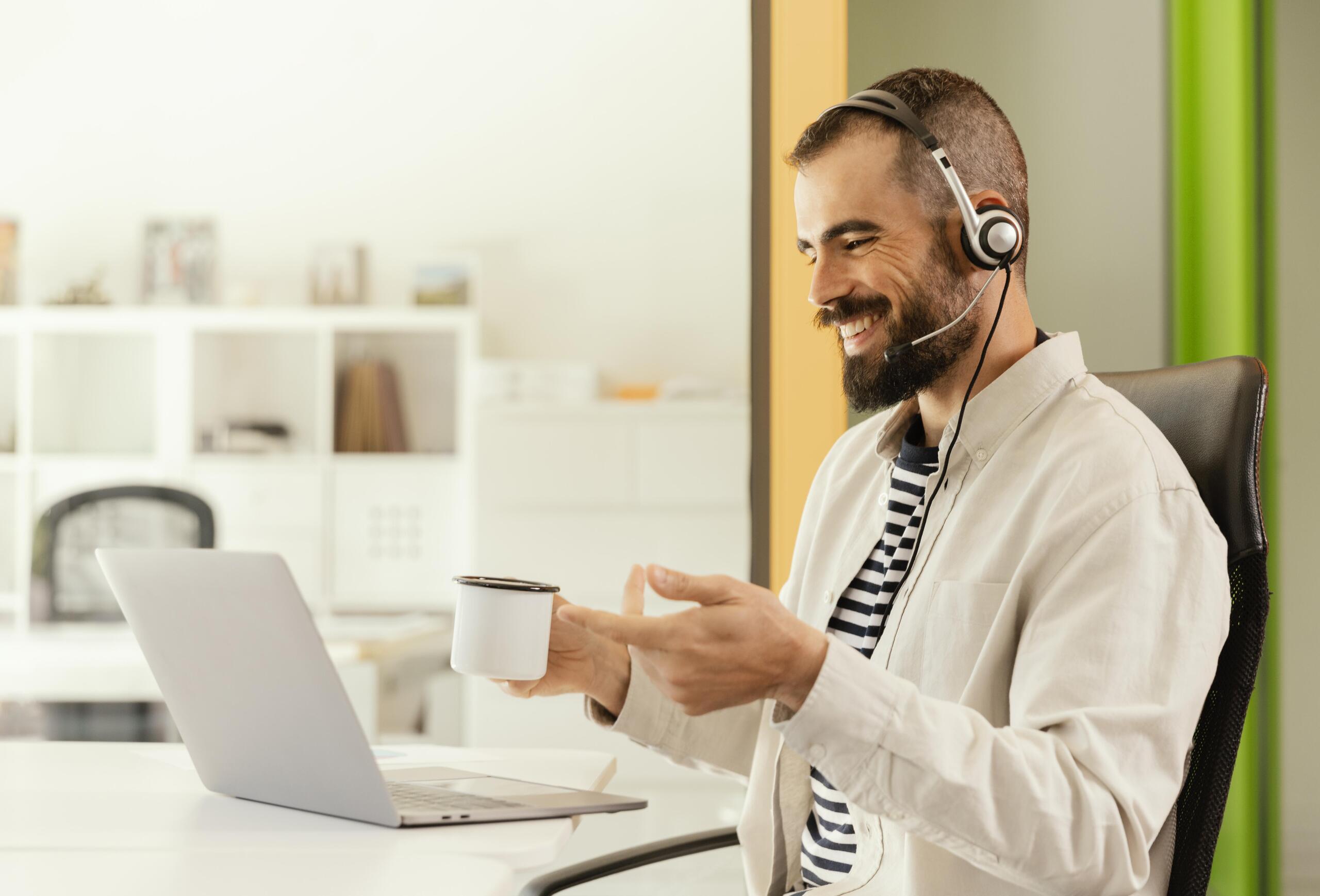 a man on a online meeting smiling and engaging in conversation 