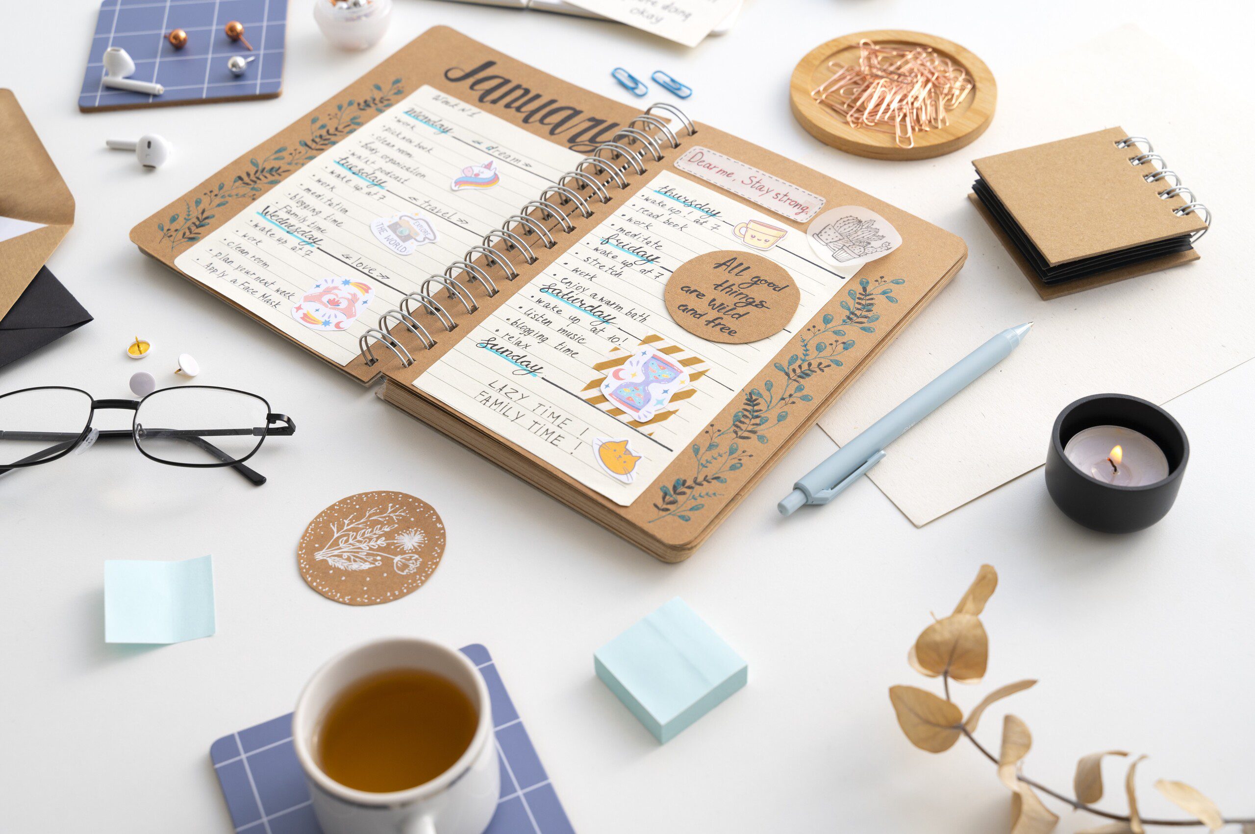 a office desk with a diary and stationary all around it